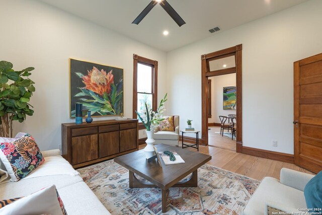 living room featuring light hardwood / wood-style flooring and ceiling fan