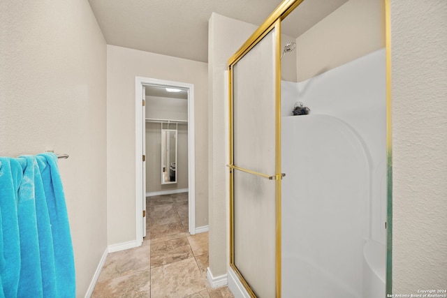 bathroom featuring a shower with door