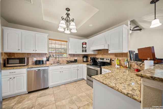 kitchen featuring tasteful backsplash, decorative light fixtures, stainless steel appliances, and light stone countertops