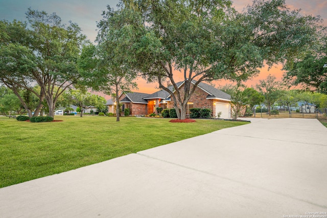 single story home featuring a lawn and a garage