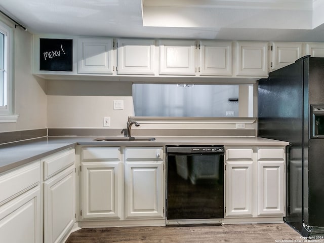 kitchen with black appliances, wood-type flooring, sink, and white cabinets