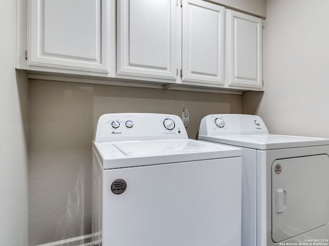 laundry room with cabinets and washer and clothes dryer