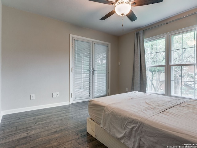 bedroom with ceiling fan, baseboards, and dark wood finished floors