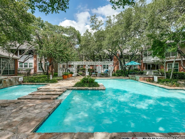 view of pool featuring pool water feature and a patio area