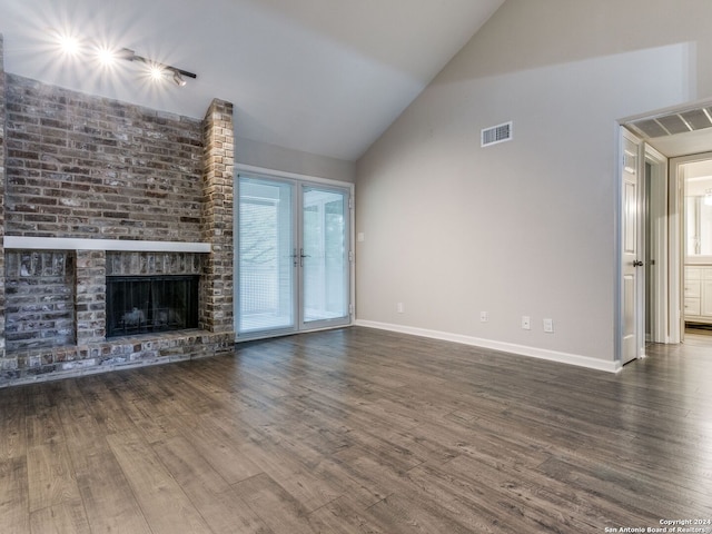 unfurnished living room featuring high vaulted ceiling, a brick fireplace, and dark hardwood / wood-style flooring