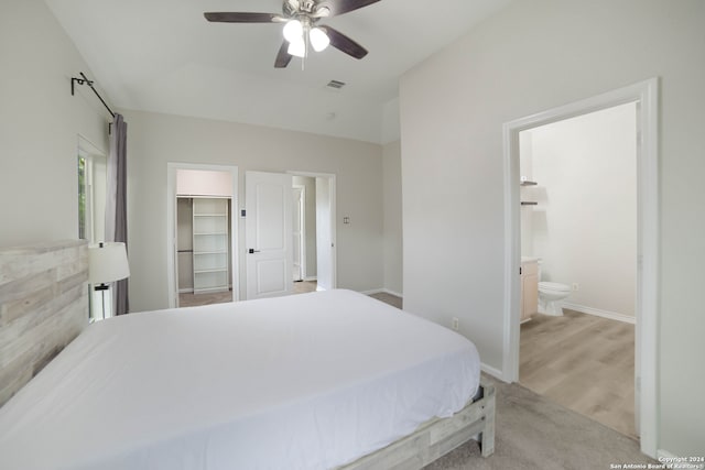 bedroom featuring light wood-type flooring, connected bathroom, ceiling fan, a closet, and a spacious closet