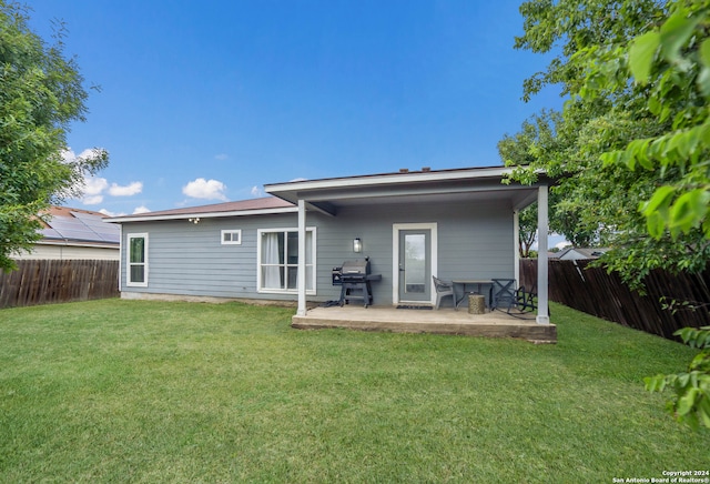 rear view of house featuring a patio area and a yard