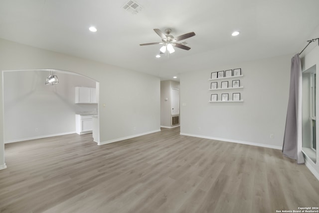 empty room with ceiling fan and light hardwood / wood-style floors