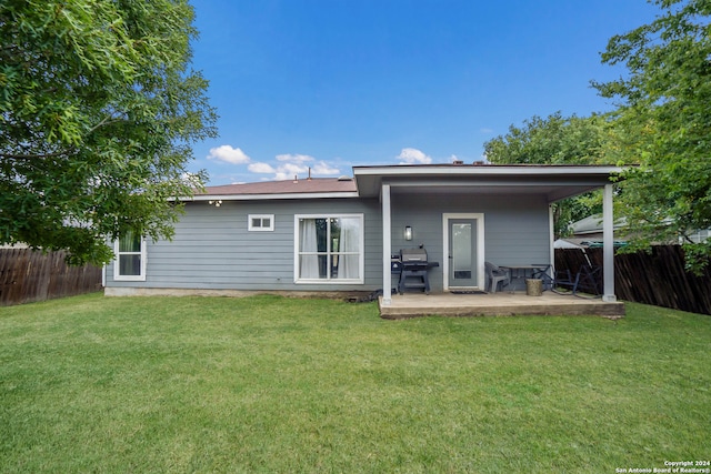 back of property featuring a lawn and a patio