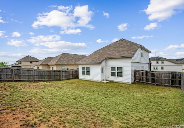 rear view of property with a yard