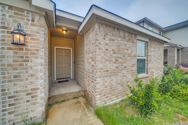 entrance to property featuring brick siding