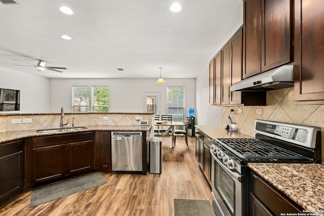 kitchen featuring light hardwood / wood-style flooring, light stone countertops, stainless steel appliances, sink, and ceiling fan