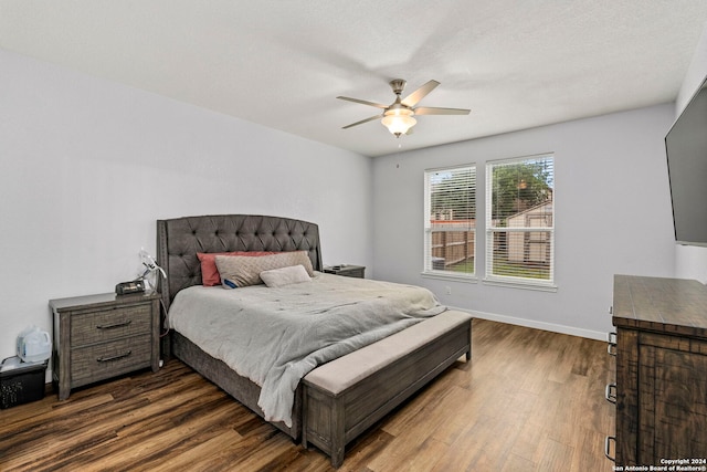 bedroom featuring a textured ceiling, ceiling fan, and dark hardwood / wood-style floors