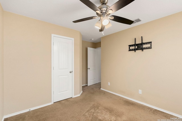 unfurnished bedroom with light colored carpet and ceiling fan