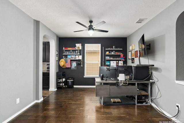 office area with a textured ceiling, dark wood-type flooring, and ceiling fan