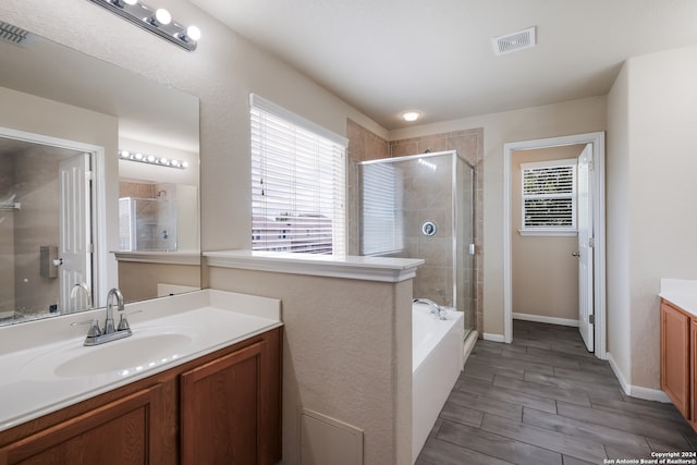 bathroom featuring vanity, hardwood / wood-style floors, and shower with separate bathtub