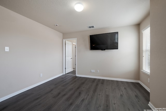 interior space featuring dark wood-type flooring and a textured ceiling