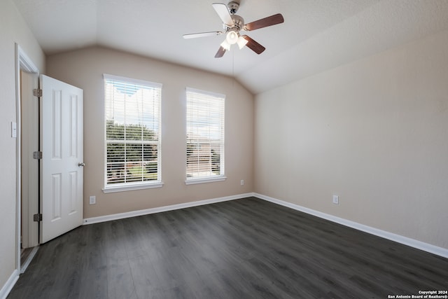 spare room with dark hardwood / wood-style flooring, ceiling fan, and vaulted ceiling