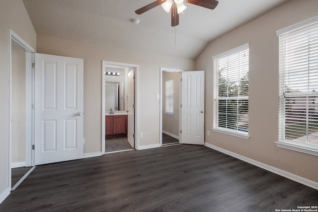 unfurnished bedroom with ensuite bathroom, lofted ceiling, a closet, dark hardwood / wood-style floors, and ceiling fan