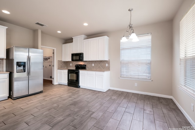 kitchen featuring black appliances, white cabinetry, and a notable chandelier