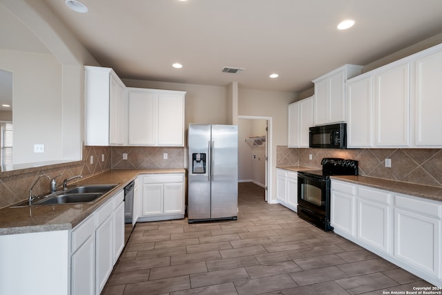 kitchen featuring black appliances, sink, white cabinets, and light hardwood / wood-style floors