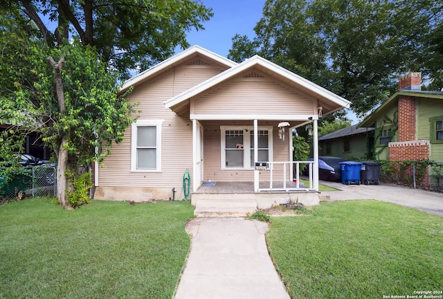 bungalow-style home with a front lawn and covered porch