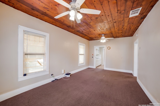 carpeted empty room with wood ceiling, a healthy amount of sunlight, and ceiling fan