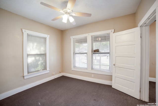 unfurnished bedroom featuring dark carpet and ceiling fan