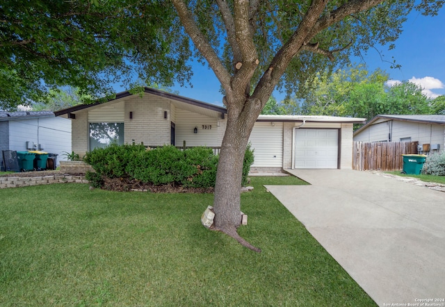 ranch-style house featuring a garage and a front yard