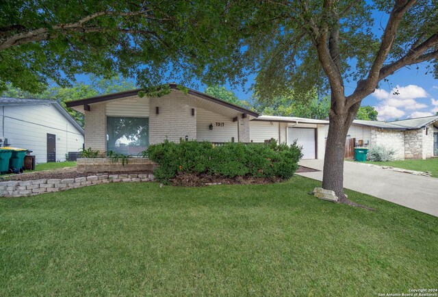 single story home featuring a garage and a front lawn