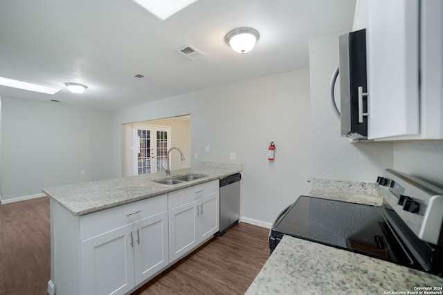 kitchen featuring dark wood finished floors, visible vents, appliances with stainless steel finishes, a sink, and a peninsula