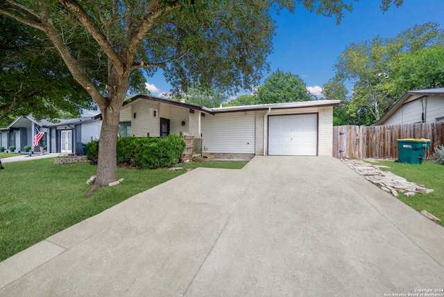 ranch-style home featuring a garage and a front lawn