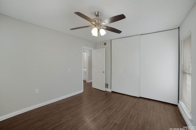 unfurnished bedroom with baseboards, visible vents, a ceiling fan, wood finished floors, and a closet