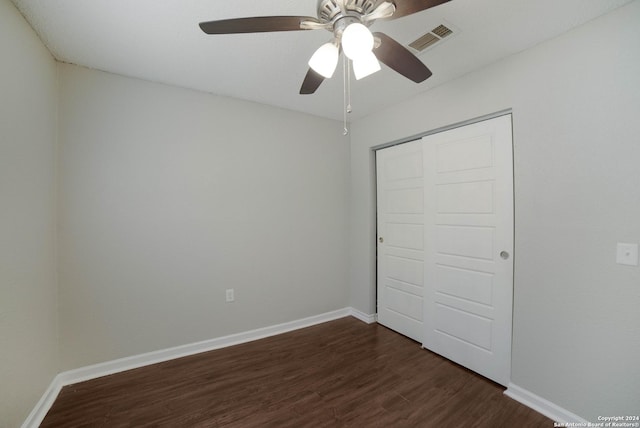 unfurnished bedroom with baseboards, a closet, visible vents, and dark wood-style flooring