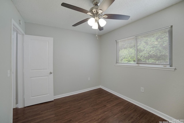 empty room featuring dark wood-style floors, a textured ceiling, baseboards, and a ceiling fan