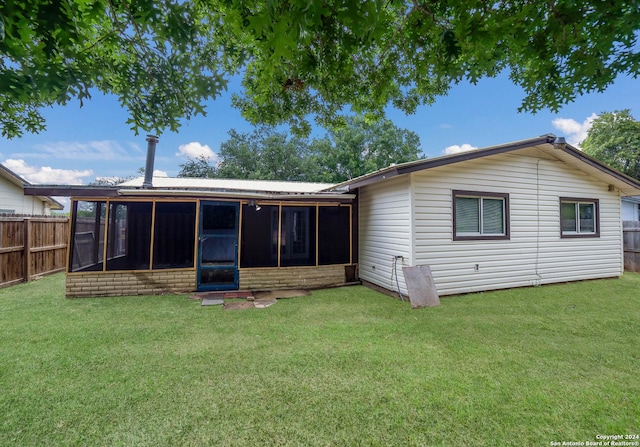 back of house with a sunroom, a fenced backyard, and a yard