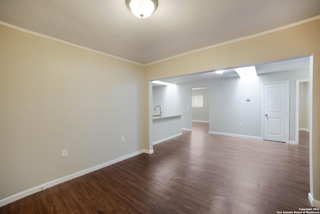 spare room featuring baseboards, dark wood finished floors, and crown molding