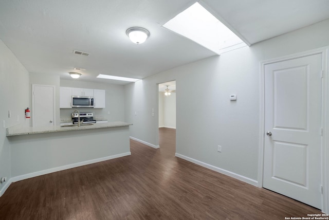 interior space with a skylight, visible vents, appliances with stainless steel finishes, dark wood-type flooring, and white cabinetry