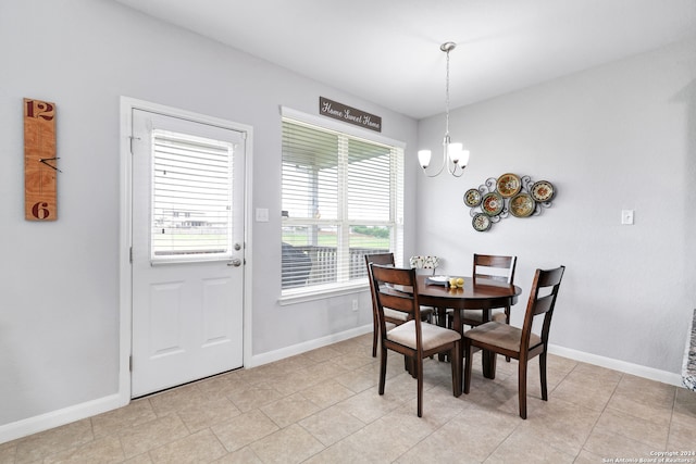 dining space featuring light tile patterned floors and a chandelier