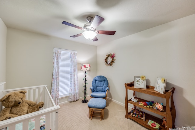 carpeted bedroom with multiple windows, ceiling fan, and a crib