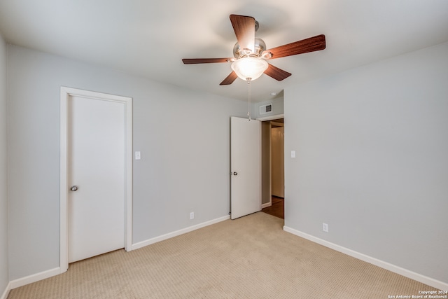 unfurnished room with light colored carpet and ceiling fan