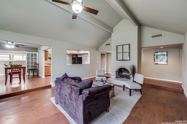 living room with lofted ceiling with beams, wood-type flooring, and ceiling fan