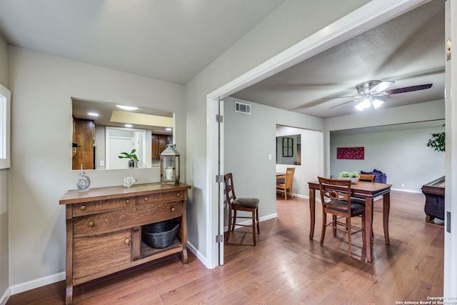 dining room with a textured ceiling, ceiling fan, and wood-type flooring