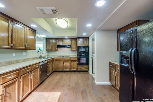 kitchen featuring black appliances, sink, and light hardwood / wood-style flooring