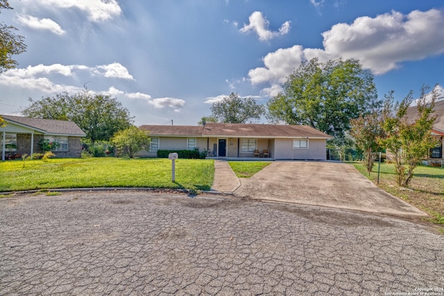 ranch-style house with concrete driveway and a front yard