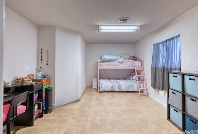 bedroom with a textured ceiling and light tile patterned floors