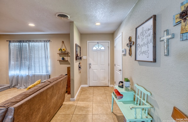 tiled foyer entrance featuring a textured ceiling