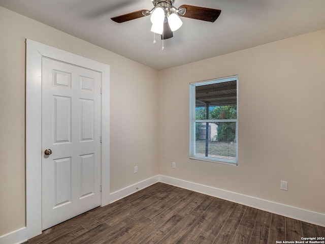 empty room featuring dark wood-type flooring and ceiling fan