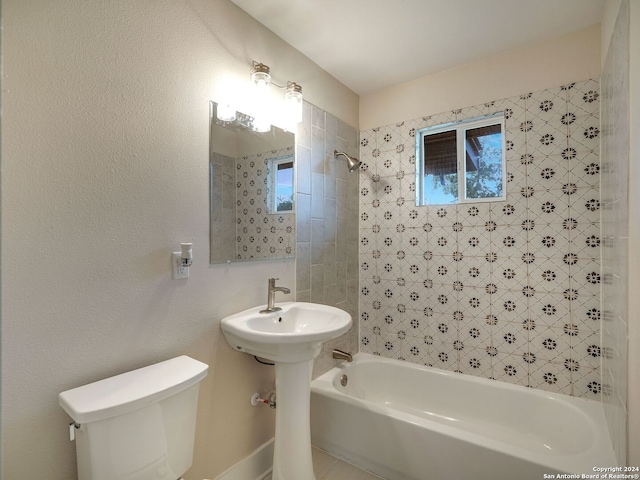 bathroom featuring tiled shower / bath combo and toilet