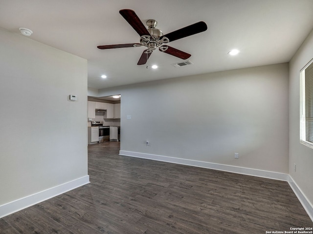 unfurnished living room with dark hardwood / wood-style flooring and ceiling fan